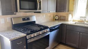 a kitchen with a stove and a microwave at Sail Away in Cape May Point