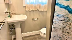 a bathroom with a sink and a toilet at Sail Away in Cape May Point +14 photos