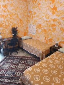 a room with two beds and a desk and a desk at Ca' della Sfinge Colibrì a Civiasco in Varallo