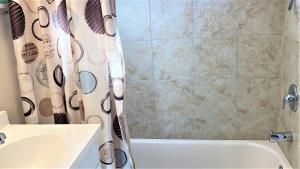 a bathroom with a shower curtain and a sink and a tub at Seamans Folly On Broad in Cape May +29 photos
