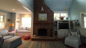 a living room with a fireplace and a tv at Cutest Cottage On Central in Cape May Point
