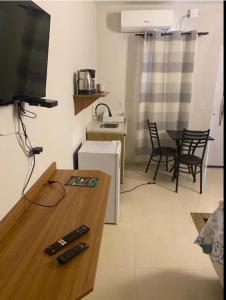a living room with three remote controls on a table at Pousada le sorelle in Rosário do Sul