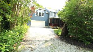 a driveway leading to a house with a white garage at The Happy Heron in West Cape May