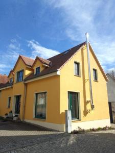 a yellow house with a brown roof at Kleine FeWo, Einstiegspreis! in Weimar