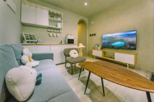a living room with a blue couch and a tv at 住安平4-7人包棟民宿 依訂購人數給房間 好停車 寵物友善酌收清潔費 in Tainan