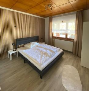 a bedroom with a bed and a window and a chair at Ferienhaus in der Altmark in Kakerbeck