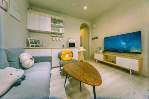a living room with a blue couch and a table at 住安平4-7人包棟民宿 依訂購人數給房間 好停車 寵物友善酌收清潔費 in Tainan