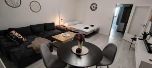 a living room with a black couch and a table at Lajlas'Suite in Vellmar in Vellmar