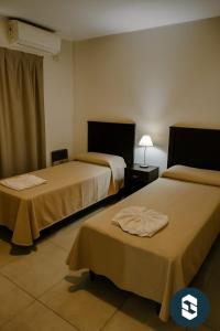 a hotel room with two beds in a room at Central Suites Hotel in Villa Carlos Paz