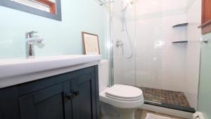 a bathroom with a sink and a toilet and a shower at Cottage On Cambridge in Cape May Point +16 photos