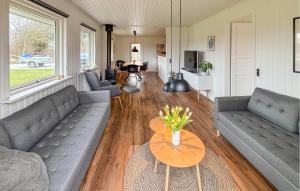 a living room with two couches and a table at Cozy Home In Sydals With Sauna in Skovby