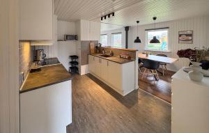 a kitchen with white cabinets and a table in a room at Cozy Home In Sydals With Sauna in Skovby