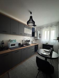 eine Küche mit Tisch und Mikrowelle in der Unterkunft Arena Royal Suite in Bacău + 43 Fotos