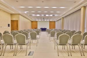 an empty room with rows of chairs and a podium at Silver Moon Hotel in Abidjan +50 photos