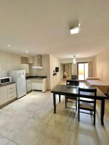 a kitchen and living room with a table and chairs at Central Suites Hotel in Villa Carlos Paz