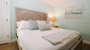 a bedroom with a large white bed with pillows at Beach Croft in West Cape May