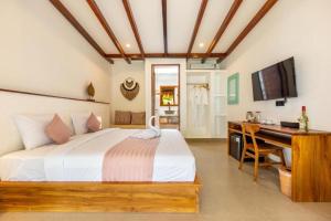 a bedroom with a bed and a desk and a computer at Roh Villas Kuta Lombok in Kuta Lombok +49 photos