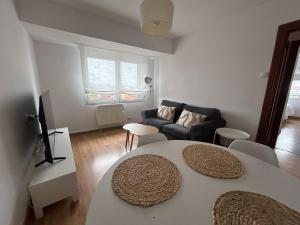 a living room with a table and a couch at La Costa Suite in Gijón