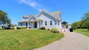 a white house with a lawn in front of it at Fairwinds Cottage in Cape May