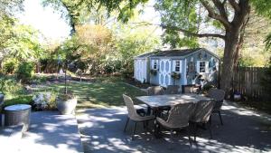 a table and chairs in a yard with a shed at The Roost Ii On Leaming in West Cape May