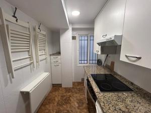 a small kitchen with a stove and a sink at La Costa Suite in Gijón