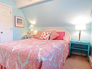 a bedroom with a bed and two tables and a lamp at Lily Pad Lake Views in Cape May Point