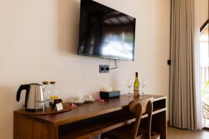 a kitchen with a wooden table with wine glasses at Roh Villas Kuta Lombok in Kuta Lombok