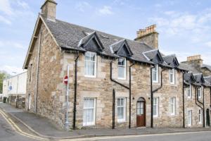 an old stone house on the corner of a street at Taigh Oisean 4 Birnam Place Pitlochry in Pitlochry