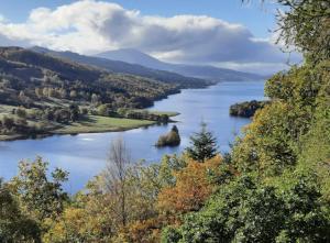 a view of a river with trees and hills at Taigh Oisean 4 Birnam Place Pitlochry in Pitlochry +5 photos