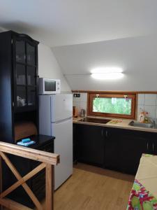 a kitchen with a white refrigerator and a microwave at Nimród Pihenőház in Egerszalók