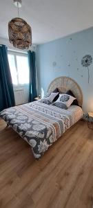 a bedroom with a large bed with a wooden floor at Agréable T2 Classé 3 étoiles, refait à neuf, dans quartier calme in Rodez