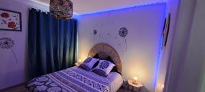 a bedroom with a bed with violet lights on it at Agréable T2 Classé 3 étoiles, refait à neuf, dans quartier calme in Rodez