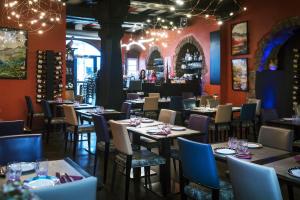 a dining room with tables and chairs and lights at Le B. Suites, Chambres & Restaurant in Riquewihr