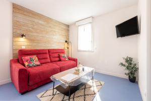 a living room with a red couch and a table at La Campana 107 in Bielle