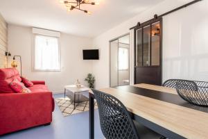 a living room with a red couch and a table at La Campana 107 in Bielle