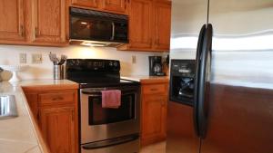 a kitchen with wooden cabinets and a stainless steel refrigerator at Relief Cape May Point in Cape May Point