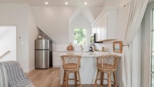 a kitchen with a sink and two bar stools at The Ocean Loft At Kings in Cape May