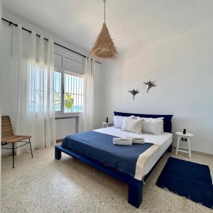 a bedroom with a blue bed and a window at Maison Azur la Marsa plage in Tunis