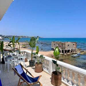 a balcony with a table and chairs and the ocean at Maison Azur la Marsa plage in Tunis