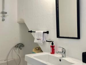 a white bathroom with a sink and a mirror at Maison Azur la Marsa plage in Tunis +9 photos