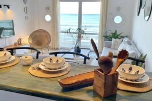 a table with plates and bowls on top of it at Lappartement Pied dans leau in Douar el Hafey