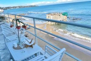 a balcony with a table and chairs on the beach at Lappartement Pied dans leau in Douar el Hafey