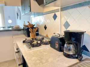a kitchen counter with a toaster on top of a stove at Lappartement Pied dans leau in Douar el Hafey +7 photos