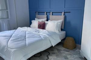 a large bed with white sheets and pillows at Lappartement Pied dans leau in Douar el Hafey