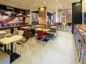 a restaurant with tables and chairs and a bar at ibis Jacarei in Jacareí