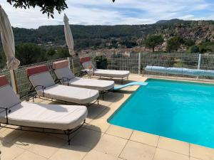 a patio with chairs and a swimming pool at Tivoli en Provence in Cotignac