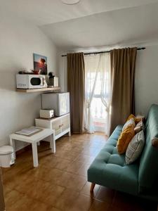 a living room with a green couch in front of a window at Centro Kennedy in Algeciras
