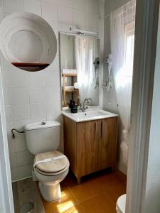 a bathroom with a toilet and a sink and a mirror at Centro Kennedy in Algeciras
