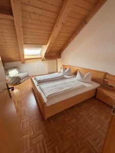 a large bed in a room with a wooden ceiling at Appartementhaus Marion in Bad Bayersoien
