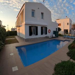 a villa with a swimming pool in front of a house at Villa Tord Massot 11 in Ciutadella